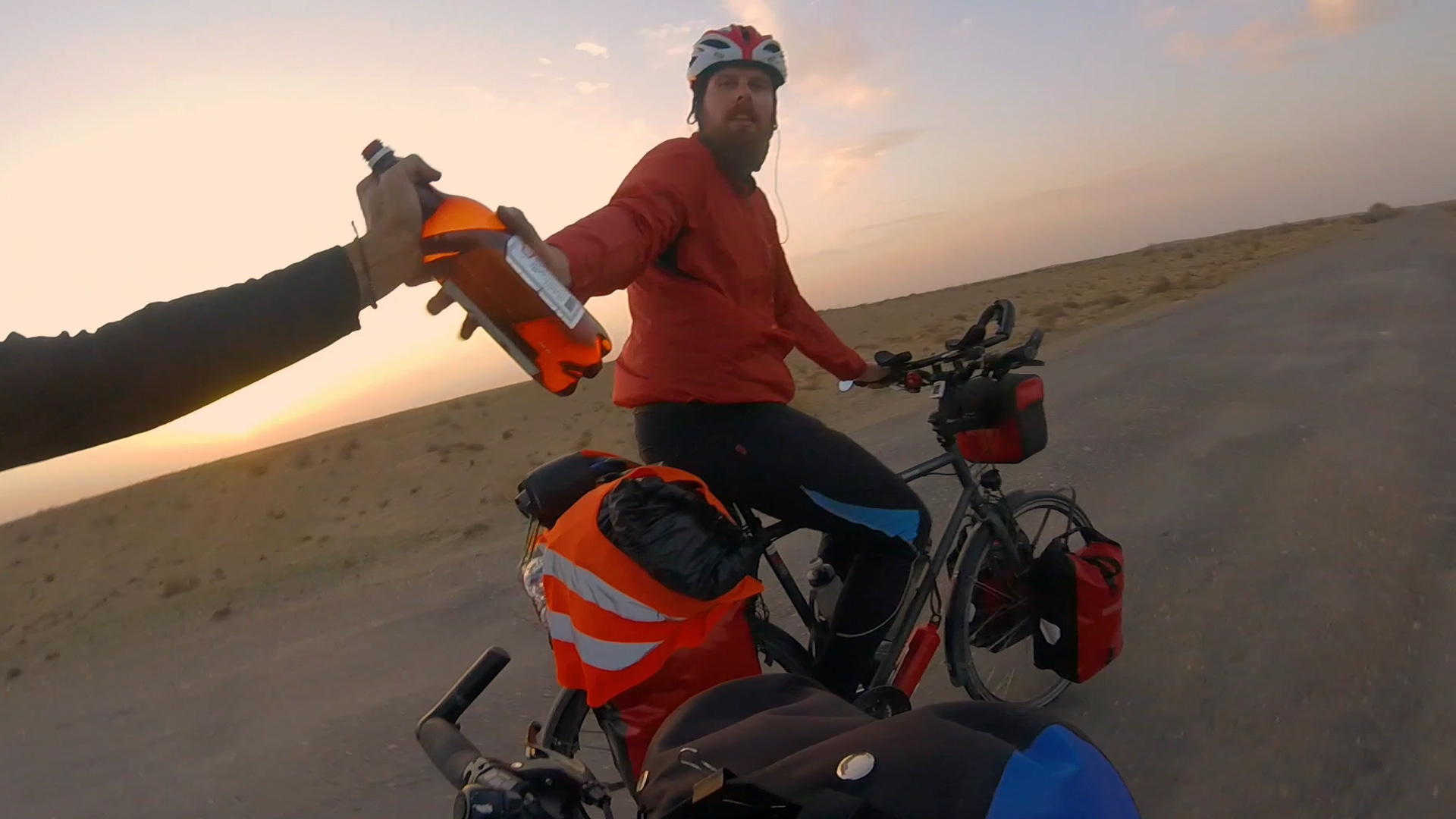 Verplant – Wie zwei Typen versuchen, mit dem Rad nach Vietnam zu fahren. Keule reicht in der Wüste dem fast verdurstenden Otti etwas zum Trinken.
